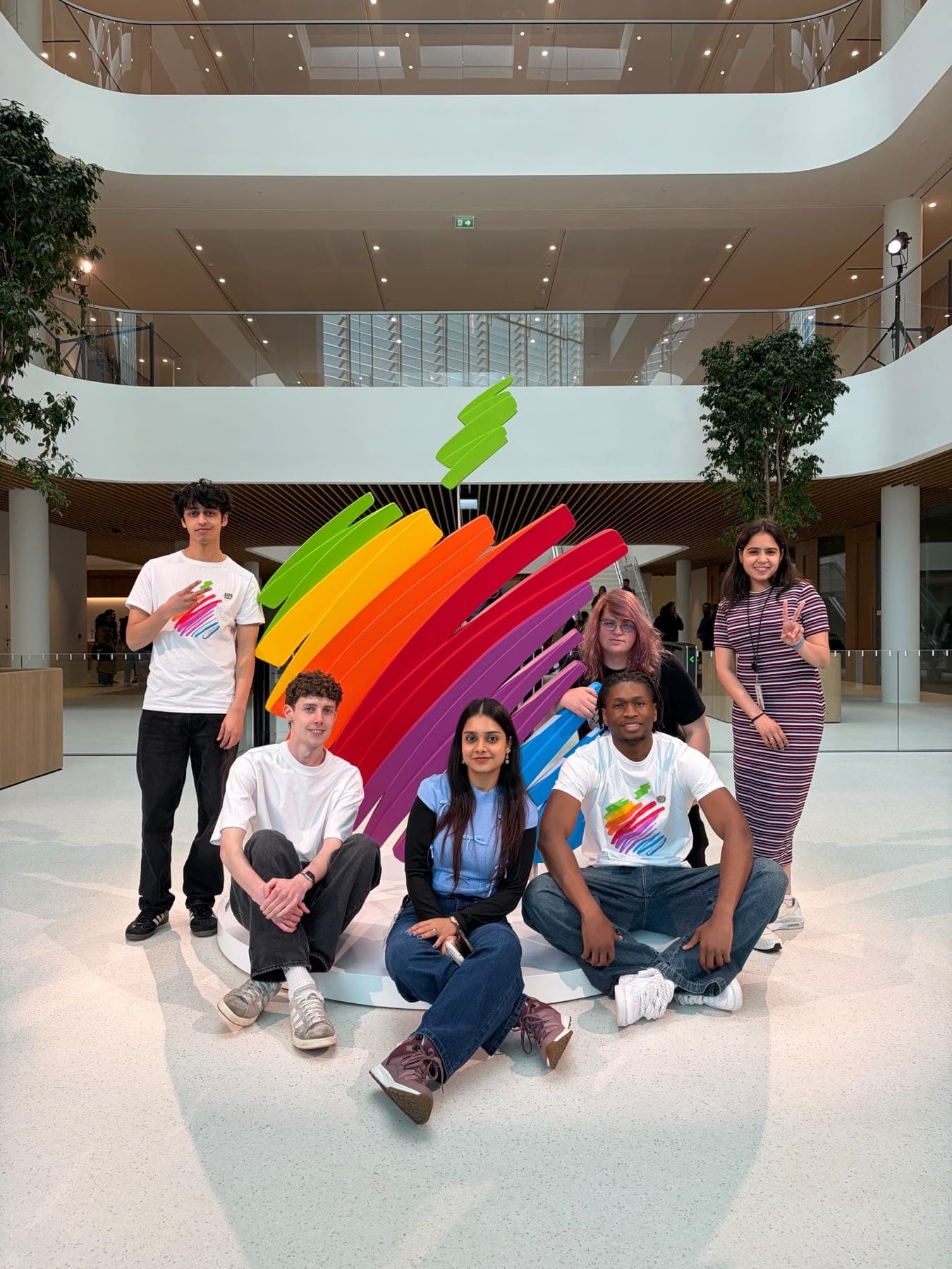 Interns gathered around the rainbow Apple sculpture in the atrium of Apple's Cork campus.